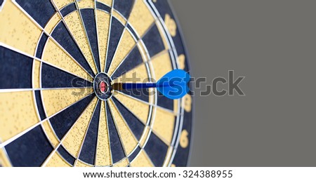 Photography of vintage yellow and black colors darts. Success hitting target aim goal achievement. Blue Dart in bull\'s eye. copy space. soft focus