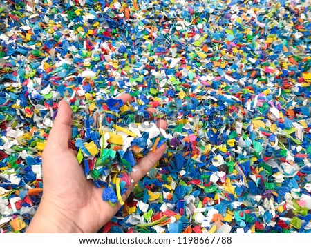Hand holding Bottle flake,PET bottle flake,Plastic bottle crushed,Small pieces of cut colorful plastic bottles