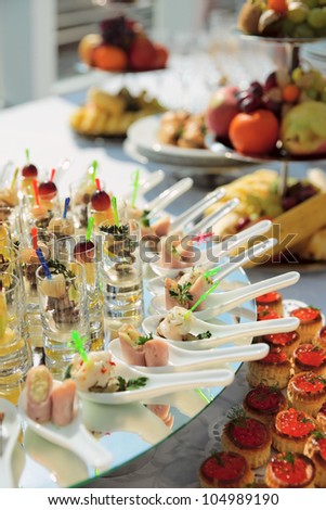 Glasses with seafood snacks on banquet table