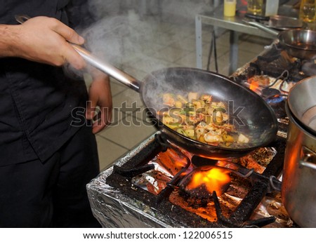 Chef is cooking seafood dish stir fry method Chef is cooking seafood dish stir fry method
