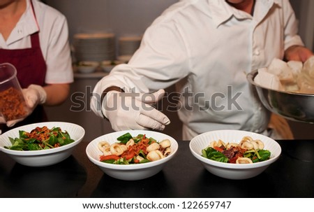 Chef is serving plates in open kitchen