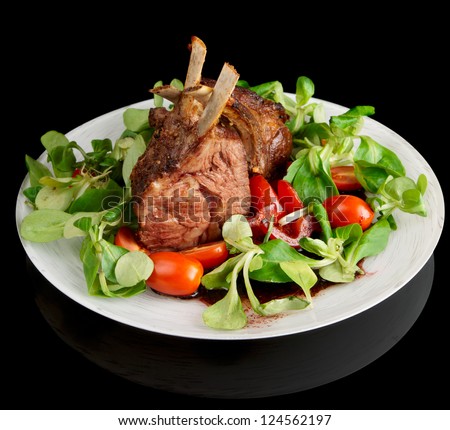 Rare fried rack of lamb isolated on black background with reflection