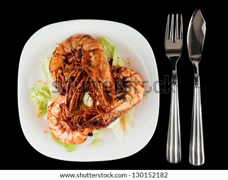 Shrimps and lettuce appetizer isolated on black background