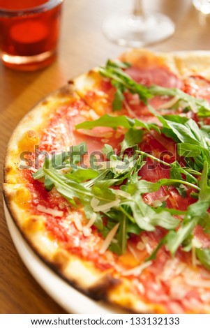 Mozzarella pizza with arugula salad on table, close-up
