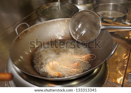 Prawns being fried in wok pan