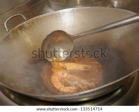 Prawns being fried in wok pan