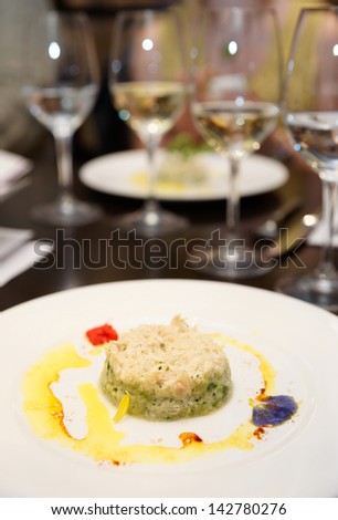 Asian style appetizer on restaurant table with glasses in background