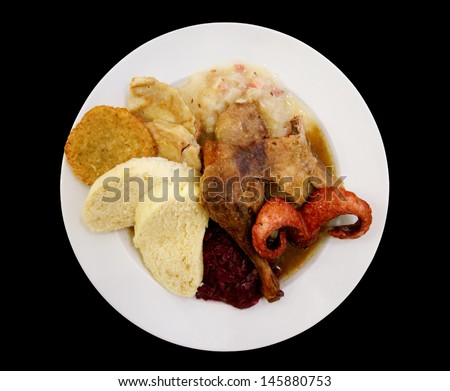 Assortment of meats, turkey and sauerkraut - traditional Czech dish isolated on black
