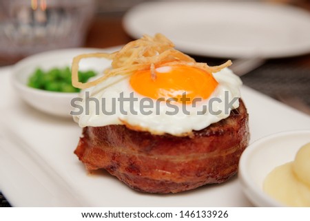 Tenderloin steak with fried egg and green pies, british dish