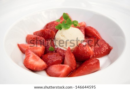 Flambe strawberries with ice cream in plate