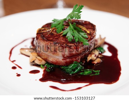 Tenderloin Steak Wrapped In Bacon With Red Sauce And Spinach
