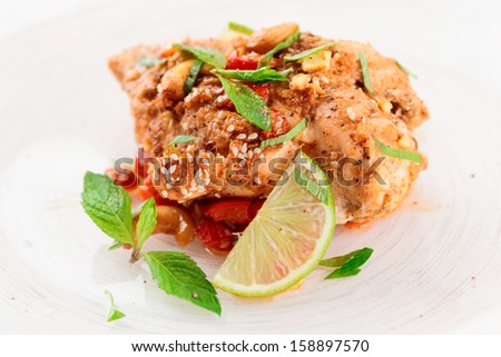 Chicken breast cooked in asian style with hot sauce, nuts and mint