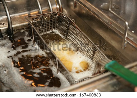 Deep fryer with boiling oil in fast food restaurant