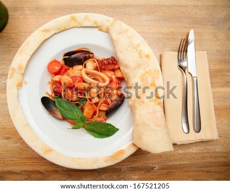 Seafood pasta cooked under pizza dough leaf