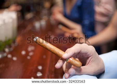 Man smoking cigar at bar counter, shallow focus
