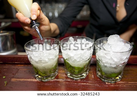Female bartender pouring juice in glass, retro styled bar
