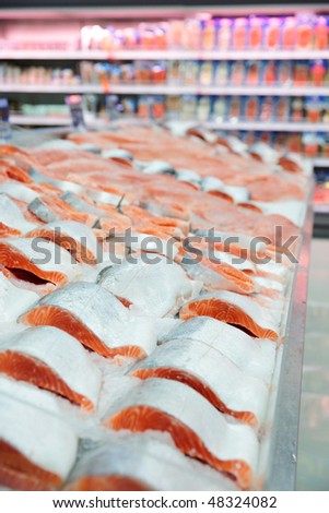 Salmon on cooled market display, shelves in blurred background