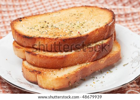 Three pieces of toasted bread with aromatic herbs ans salt