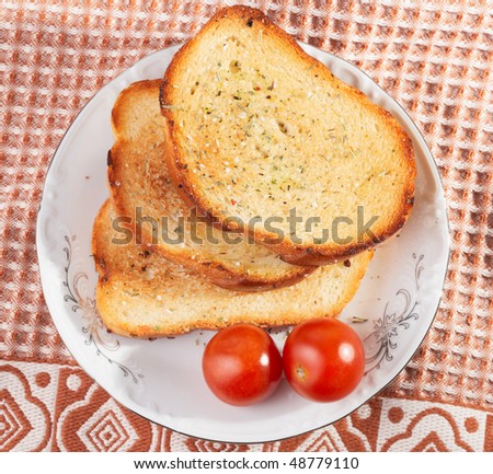 Three pieces of toasted bread and cherry tomatos