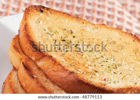 Three pieces of toasted bread with aromatic herbs and salt, close-up