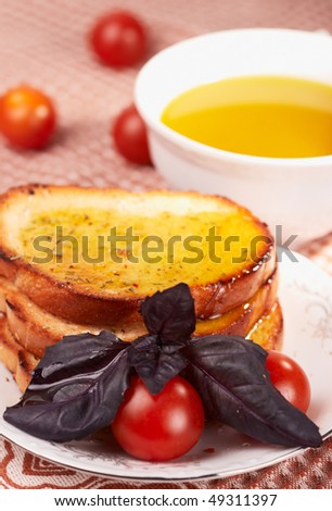Three pieces of toasted bread and cherry tomatos, with olive oil on bread