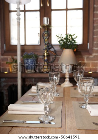 Table in a rustic cuisine restaurant, focus is on the glass
