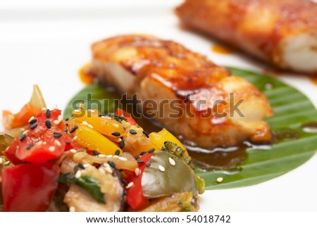 Asian style fried seafood on plate, focus on vegs
