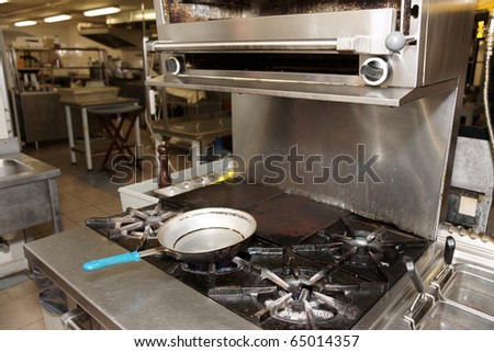 Hot busy kitchen with gas range in foreground