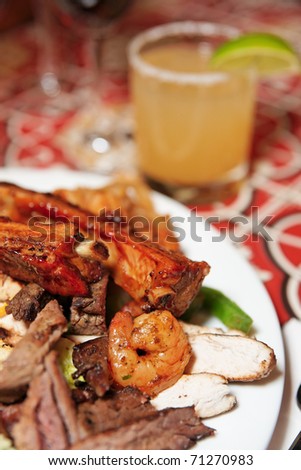 Grilled pork ribs, beef and shrimps with cocktail - perfect dinner