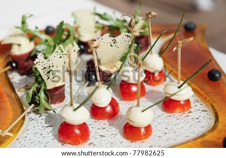 Canapes with buffalo cheese, ham and cherry tomatos