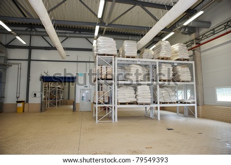 Large food warehouse with steel shelves ans sugar sacks