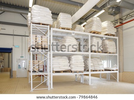 Large food warehouse with sugar sacks on steel shelves