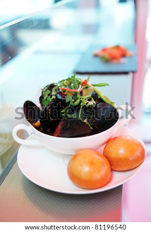 Plate of asian style cooked mussels with dim sum on takeout restaurant counter
