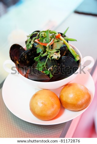 Plate of asian style cooked mussels with dim sum on takeout restaurant counter