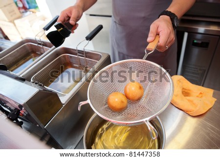 Chef cooking dim sum in a deep fryer - asian takeout food