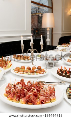 Meat and fish appetizers on table
