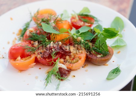 Simple appetizer with cherry tomatoes and smoked duck fillet