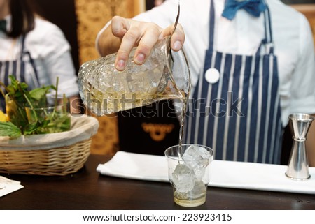 Bartender is making cocktail behind the bar