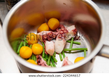 Pot with vegetables and sliced octopus