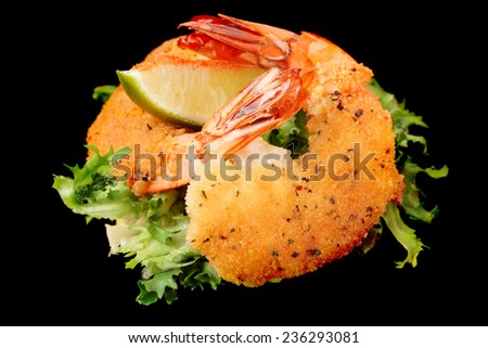Deep fried shrimps with lettuce isolated on pure black background