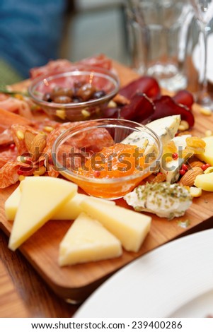 Cheese and sausage platter with nuts and citrus jam, copy space