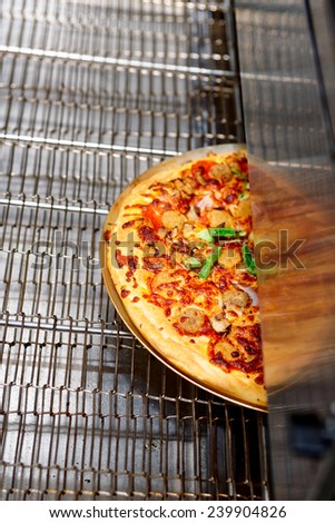 Just baked pizza coming from an industrial oven
