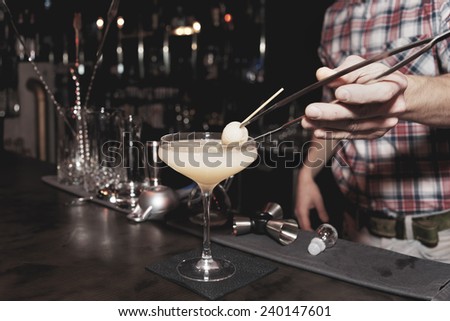 Bartender is making a cocktail with leechee, toned image
