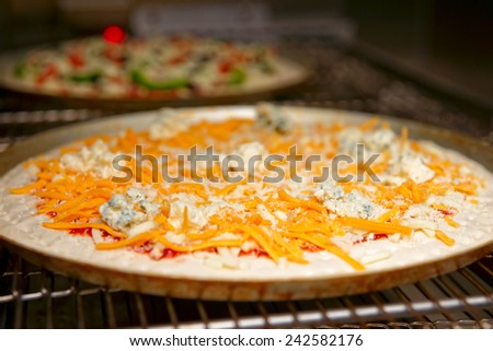 Cheese pizza entering the industrial oven