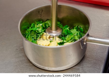 Making parsley sauce with blender at commercial kitchen