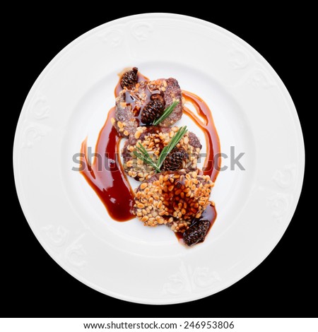 Venison fillet fried with pine nuts, served with sweet sauce, isolated