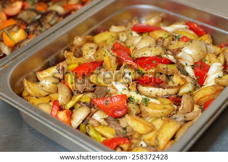 Steel container with potato wedges and vegetables