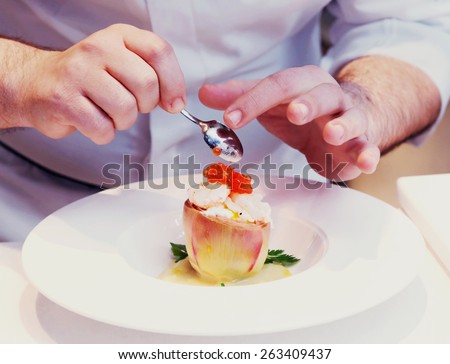 Chef is cooking a seafood appetizer, close-up, toned image
