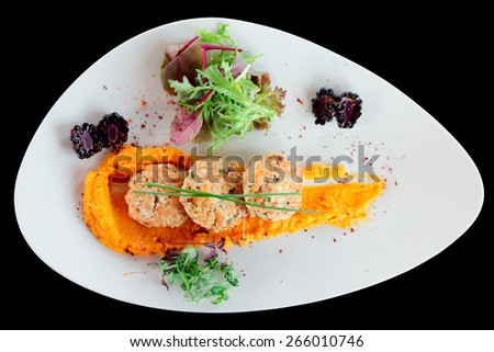 White meat patty cakes with pumpkin mash, isolated on black background