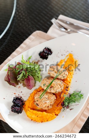 White meat patty cakes with pumpkin mash on restaurant table